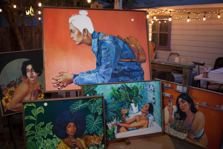 several paintings leaning on easel and floor
