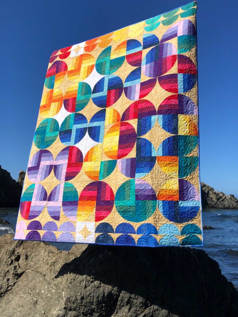Colorful quilt displayed by shore