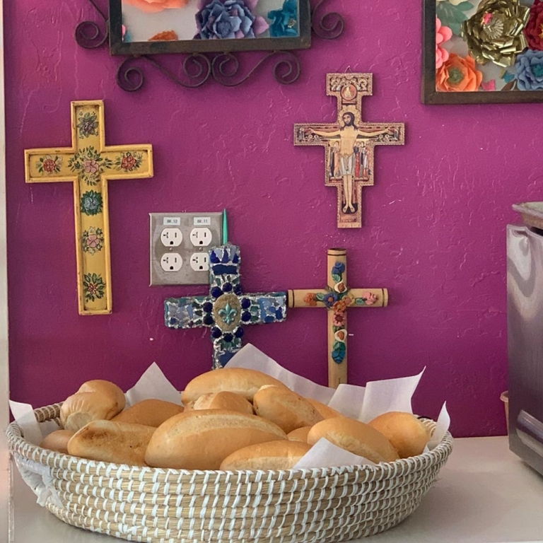 Basket of bread, wall of crucixes