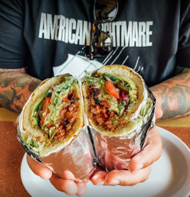 hands holding a burrito cut in half to display the inside