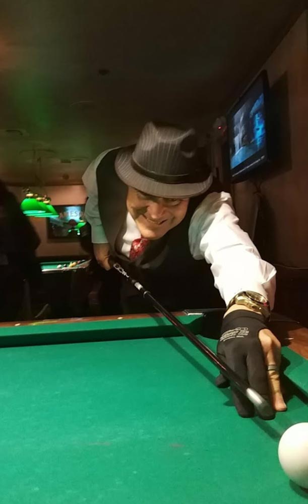 Belvedere man in hat playing pool