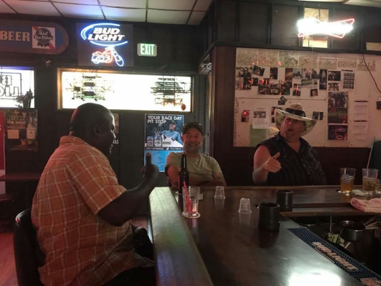 three people sit at the bar