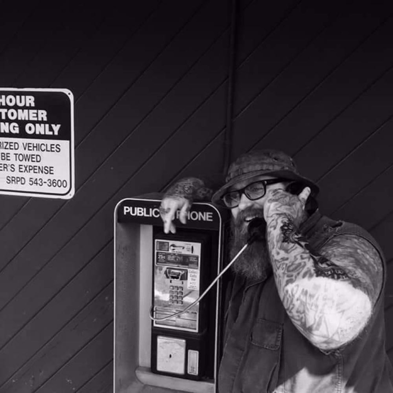 a man using a telephone in black and white