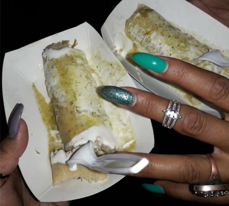woman with long polished nails holding Mexican food