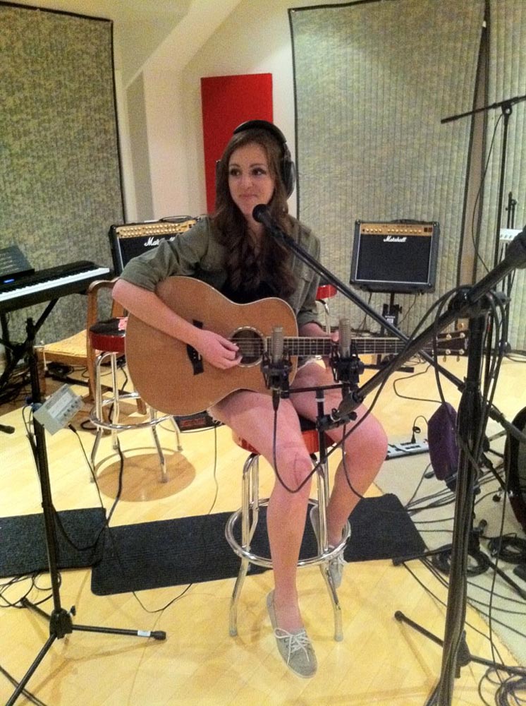musician playing guitar surrounded by equipment