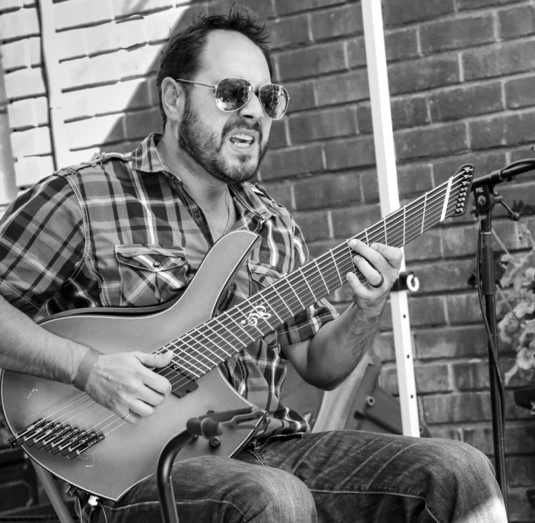 bw photo Nate Lopez singing and playing