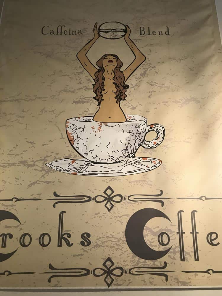 sign of Mermaid in coffee cup holding bean with Crooks Coffee written below