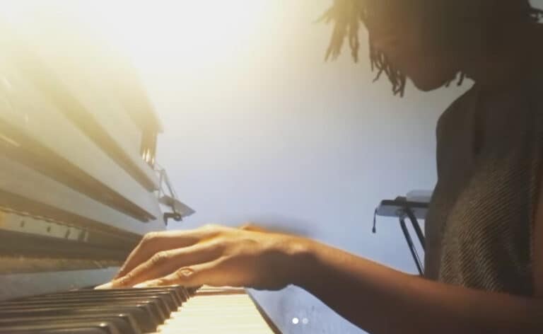 Woman playing piano with sun behind